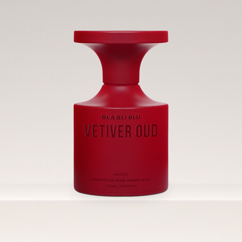 Red vetiver  perfume bottle labeled 'Vetiver Oud' on a light gray background