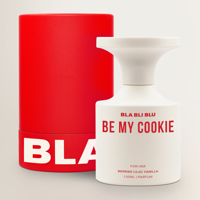 White perfume bottle with red text next to a red container on a light gray background